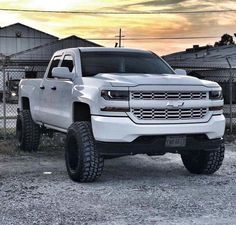 a white truck parked in front of a fence