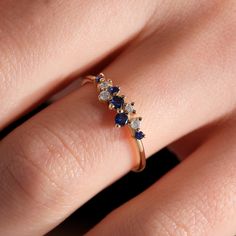 a woman's hand with a diamond and sapphire ring