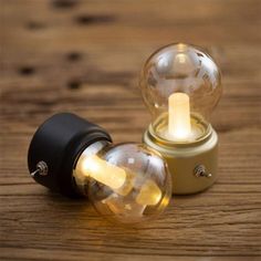 two light bulbs sitting on top of a wooden table