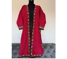 Add a unique and exotic touch to your wardrobe with this Turkmen silk kaftan, also known as a kimono or chapan. This original piece from the 1960s is a great addition to any collection. It is made of hand-woven silk and cotton fabrics used as lining. All embroidery is made of silk. Used. Showcases the vibrant and colorful Turkmen project design. The multicolored silk material adds a luxurious touch to the piece. Perfect for cultural events, this Turkmen traditional garment is a must-have for fas Traditional Red Long Sleeve Kaftan, Traditional Handloom Kaftan For Eid, Festive Long Sleeve Kaftan With Woven Motifs, Traditional Multicolor Kaftan With Embroidered Border, Red Folk Style Kaftan For Festive Season, Bohemian Ceremonial Kaftan With Dabka, Red Folk Style Kaftan For Festive Occasions, Bohemian Ceremonial Kaftan With Dabka Detailing, Traditional Kaftan With Woven Motifs For Festival