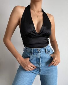 Elevate your style for your next party or night out with our stunning halter crop top. The halter neck tie adds an elegant touch and chic twist to this sleek satin design. Stay comfortable and fabulous all season long in this sleeveless top. More Details: - Runs smaller than most - Does not stretch - Halter tie - Plunging neckline - Pleated - Cropped style - 95% Polyester 5% Spandex - Color may vary due to the lighting - Model is wearing a size small Model Details Height 5'7 | Chest 34" Cup size Satin Design, Halter Crop Top, Cropped Style, Cup Size, Black Crop Tops, Plunging Neckline, Black Media, Halter Neck, Neck Tie