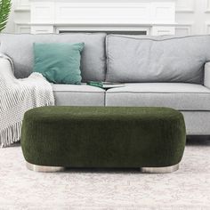 a living room scene with focus on the sofa and footstool in the foreground