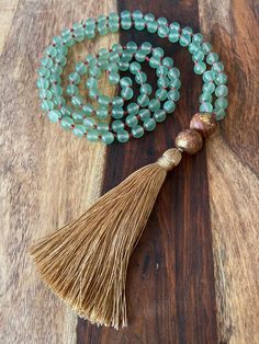 "Hand knotted Mala Necklace using 108 Jade beads with two gold foiled wooden Guru beads. This necklace measures 40\" in length with a 4\" tan tassel." Knotted Mala, Hand Knotted Necklace, Knotted Necklace, Beaded Tassel Necklace, Lucky Stone, Yoga Jewelry, Mala Necklace, Necklace Long, Fabulous Jewelry