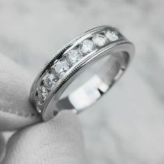 a white gold wedding ring with five diamonds on it's side and in the middle