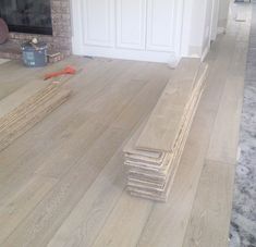 a pile of wood sitting on top of a hard wood floor next to a fire place