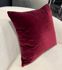 a red pillow sitting on top of a white couch