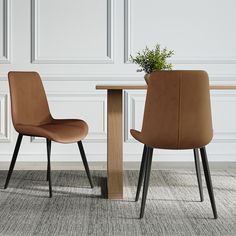 two brown chairs sitting at a wooden table