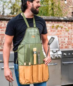 a man wearing an apron and cooking utensils in front of a bbq