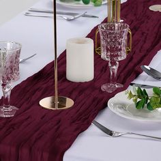 the table is set with wine glasses, candles and silverware for an elegant dinner