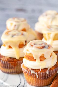 cinnamon roll cupcakes with icing and cinnamon sticks