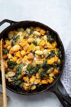 a skillet filled with potatoes and spinach