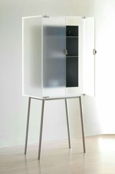 a white cabinet sitting on top of a wooden floor