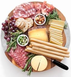 a plate with cheeses, meats and other foods on it is shown in an instagram