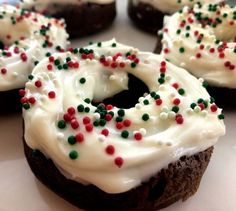 frosted donuts with sprinkles and white icing on a plate