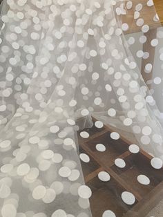 white polka dot sheer fabric on top of a wooden table