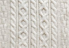 a white knitted blanket is shown in close up