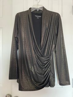 "Elevate your wardrobe with this stunning Soft Surroundings black and gold metallic faux wrap top blouse. Perfect for any occasion, this classic tunic style blouse features a flattering V-neckline.The solid pattern in black and metallic gold adds a touch of glamour to your look, while the polyester material makes it packable and easy to wear all year round. This large sized blouse is in great used condition, suitable for casual wear, workwear, business, and even party/cocktail events. The blouse is a must-have for any fashion-conscious woman who wants to look stylish without compromising on comfort. Get your hands on this Soft Surroundings blouse today and take your fashion game to the next level! Measurements with pictures: Armpit to armpit 22\" Waist 18\" Hip 21\" Long 28\" Sleeve 25\"" Elegant V-neck Holiday Tops, Holiday V-neck Blouse For Night Out, Chic V-neck Holiday Tops, Elegant Long Sleeve Faux Wrap Blouse, Fall V-neck Faux Wrap Blouse, Fall Party Blouse With Surplice Neckline, Chic Long Sleeve Wrap Top For Party, Fall Faux Wrap V-neck Blouse, Gold V-neck Blouse For Work