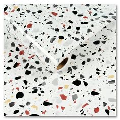 a white wrapping paper with black, red and yellow spots on the top of it