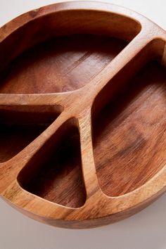 an oval wooden tray with three compartments on the bottom and one section divided into four sections