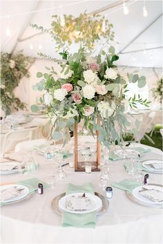 the table is set with white and green flowers