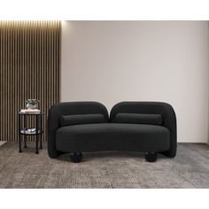 two black couches sitting next to each other in front of a wall with vertical blinds