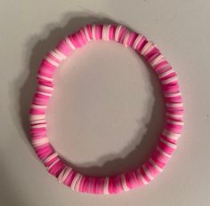 a pink and white bracelet on a table