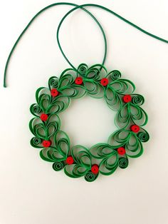 an ornament made out of green paper with red buttons