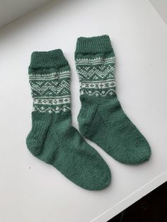 Beautiful hand knitted socks  by myself on 4 double ended needles. In a 4ply sock wool. Content is 45% Alpaca, 30% Polyamide and 25% Wool. Wool wash at 30 degrees. The colour is forest green. The pattern is nordic design and done in an  off white colour. The socks are soft and warm.  Measurements To fit size 35/37 Heel to toe 20cm top of rib to sole 26cm Comfortable Green Winter Socks, Green Winter Socks, Cozy Green Socks For Winter, Casual Green Knitted Socks, Handmade Green Socks For Winter, Handmade Green Winter Socks, Casual Handmade Green Socks, Comfortable Handmade Green Socks, Handmade Cozy Green Knitting Pattern