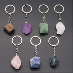 six key chains with different colored rocks hanging from it's ends, all in various shapes and sizes