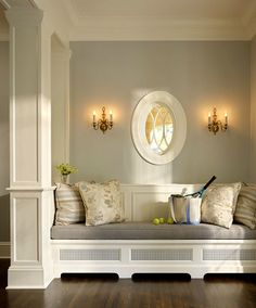 a living room filled with lots of furniture and pillows on top of a wooden floor