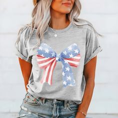 Get ready to add a touch of patriotic flair to your wardrobe with the "Stars and Stripes Bow" Tee – a stylish nod to the timeless symbols of American pride. Crafted from premium fabric, this tee ensures both comfort and durability, making it perfect for all your summer adventures. The design features a charming array of stars and stripes bows, capturing the essence of Americana charm and celebrating the spirit of freedom and unity. Whether you're celebrating Independence Day, attending a barbecue, or simply embracing your love for all things red, white, and blue, this tee is the perfect choice. Its relaxed fit guarantees comfort, while the playful design adds a touch of fun to any outfit. From backyard gatherings to beachside picnics, this tee is a versatile addition to your summer wardrob All Things Red, American Pride, Summer Adventures, Stars And Stripes, Playful Design, Red White And Blue, Independence Day, Design Features, Red White