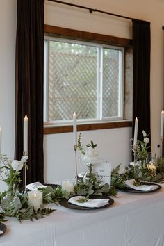 the table is set with white flowers and candles