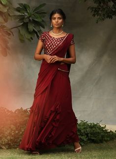 Editor's Note Blouse Is Embellished With Stone Work Maroon Drape Saree Set Fabric: Georgette And Silk Color: Maroon Care: Dry Clean Only About the Designer Nidhika Shekhar Label Is an Exclusive Designer Wear For Women Which Was Launched In 2014. The Label Is A Perfect Amalgamation Of Indian Aesthetics Incorporated In Unique Silhouettes. Their Main Area Of Focus Is Designing Which Fits/suits The Client And They Are Known For The Unique Silhouettes In The Industry. Festive Floor-length Blouse With Mirror Work, Embellished Blouse With Traditional Drape For Diwali, Diwali Embellished Traditional Drape Blouse, Embellished Pre-draped Georgette Saree For Celebration, Embellished Traditional Drape Blouse For Diwali, Embellished Traditional Drape Blouse For Navratri, Bollywood Style Embellished Traditional Drape Blouse, Bollywood Style Embellished Blouse With Traditional Drape, Embellished Georgette Traditional Wear For Navratri