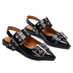 a pair of black shoes with metal buckles on the front and back straps,