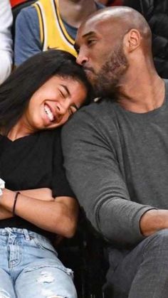 a man and woman sitting next to each other at a basketball game