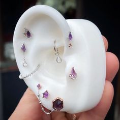 a person is holding an ear with jewelry on it