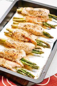 chicken and asparagus on a baking sheet