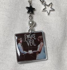 a keychain with two charms attached to it's sides, one is holding a book and the other has a star