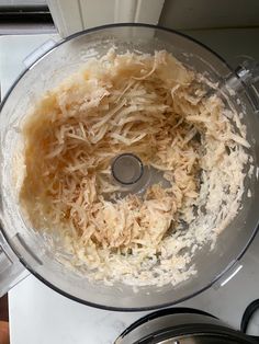 a food processor filled with shredded cheese on top of a counter