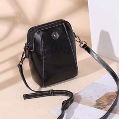 LOW STOCK WARNING Irene Genuine Leather Crossbody Bag is a small-sized bag that is made from genuine leather and cowhide. The bag can fit in things such as your cell phone, wallet, keys, and lip balm. It is perfect for someone who doesn't want to carry too many things with them but still needs the convenience of the it Trendy Black Handheld Phone Bag, Leather Phone Shoulder Bag, Leather Handheld Phone Bag With Adjustable Strap, Portable Leather Phone Shoulder Bag, Black Handheld Phone Bag For Travel, Black Handheld Phone Bag, Handheld Black Phone Bag For Travel, Portable Leather Satchel Phone Bag, Black Leather Portable Phone Bag