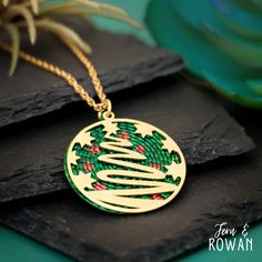 This Christmas Tree Pendant Necklace is a beautiful gift for anyone who is enchanted with the Christmas Holiday!  This Brass Holiday Christmas Tree Pendant features a Festive Christmas Tree design that has been carefully handmade and painted in our studio. Christmas Trees was a symbol of protection and renewal during the darkest winter in many ancient cultures. Today the Christmas Tree has become as a sign of everlasting life, peace, and rebirth. This brightly colored Pendant Necklace has an eye Festive Round Christmas Jewelry, Round Christmas Necklace As Gift, Green Christmas Jewelry For Festive Occasion, Green Jewelry For New Year's Gift, Green Jewelry For New Year Gift, Personalized Jewelry For Holidays, Green Jewelry As A New Year Gift, Christmas Gift Necklace, Christmas Holiday Green Jewelry