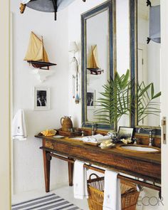 a bathroom with a sink, mirror and potted plant