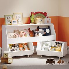 a child's room with toys and bookshelves on the floor in front of an orange wall