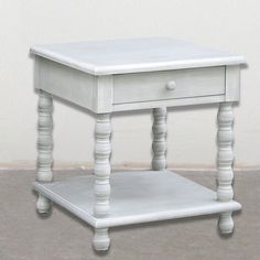 a small white table with two drawers on each side and one drawer at the top