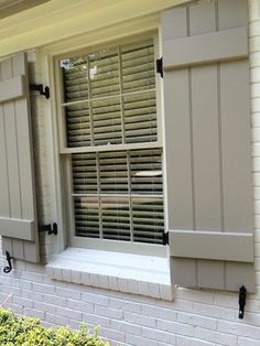 an open window with shutters on the side of a house