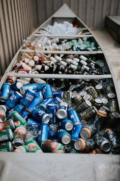 a boat filled with lots of cans and cans next to another boat full of beer