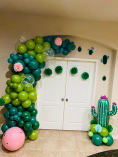 a room with balloons and cactus decorations on the wall next to two doors that are decorated in green and pink