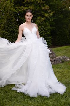 a woman in a white dress is standing on the grass