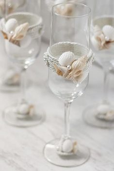 several wine glasses with seashells in them