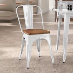 two white chairs sitting next to each other on top of a tile floored floor